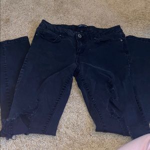 Black jeans with holes down the leg.